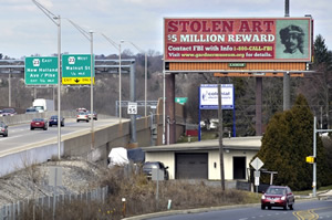 Poster on highway announcing reward for recovery of stolen  paintings.